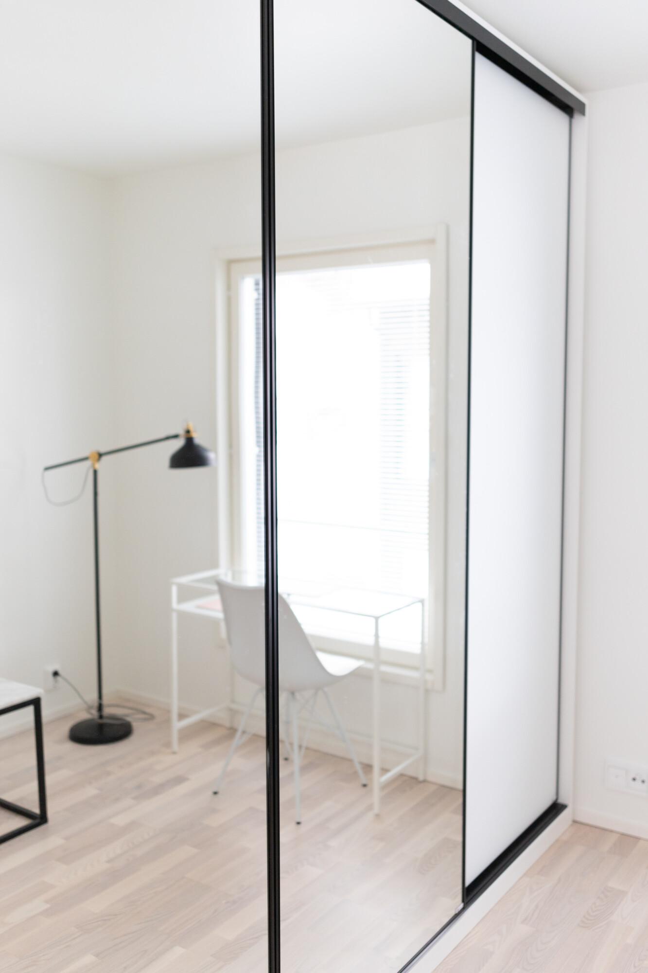 Garderob med spegelskjutdörrar i ett hemmakontor